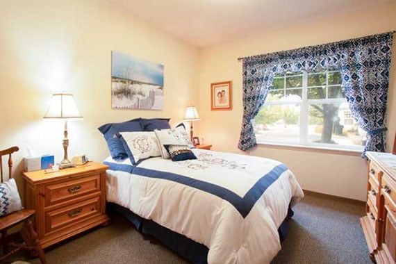 A cozy bedroom with elegant decor and a window letting in natural light.