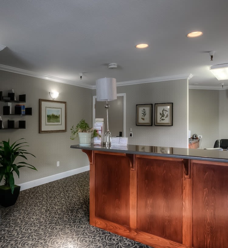 A well-decorated reception area with a wooden desk and modern furnishings.