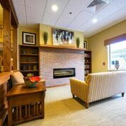A cozy living room featuring a modern fireplace and comfortable seating.