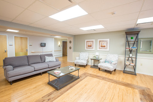 A cozy and inviting living room space featuring a sofa, armchairs, and a coffee table, illuminated by natural light.