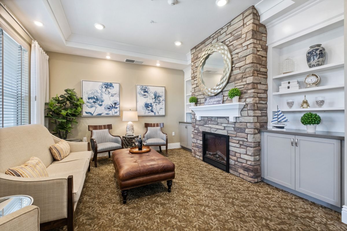 A cozy living room with a stone fireplace, modern decor, and comfortable seating.