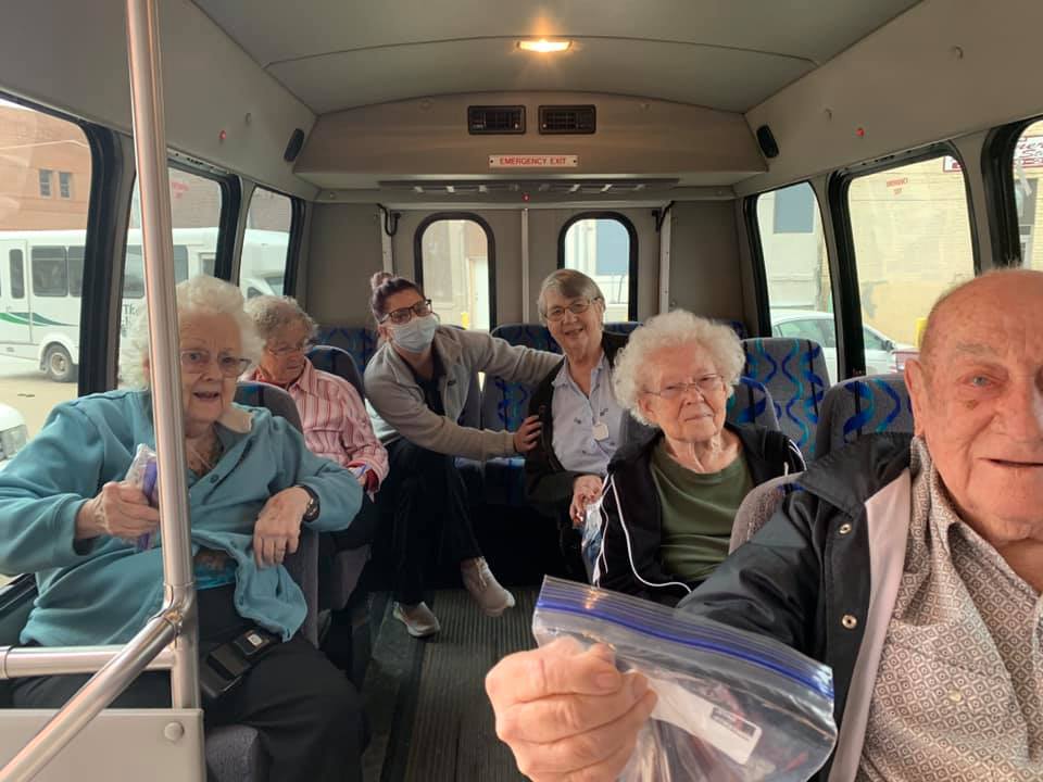 A group of elderly people seated in a bus, possibly on an outing.