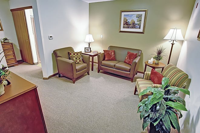 A cozy living room with sofas, chairs, and decorative elements.