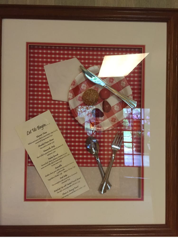 A framed decorative piece featuring a checkered background, utensils, and a menu.