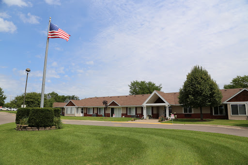 A peaceful residential building with a flag flying in the foreground under a clear sky.