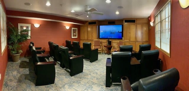 A cozy home theater room with comfortable seating and a large screen for viewing.