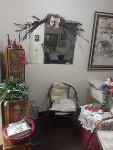 A cozy corner featuring a seating area with decorative plants, a mirror, and artwork.