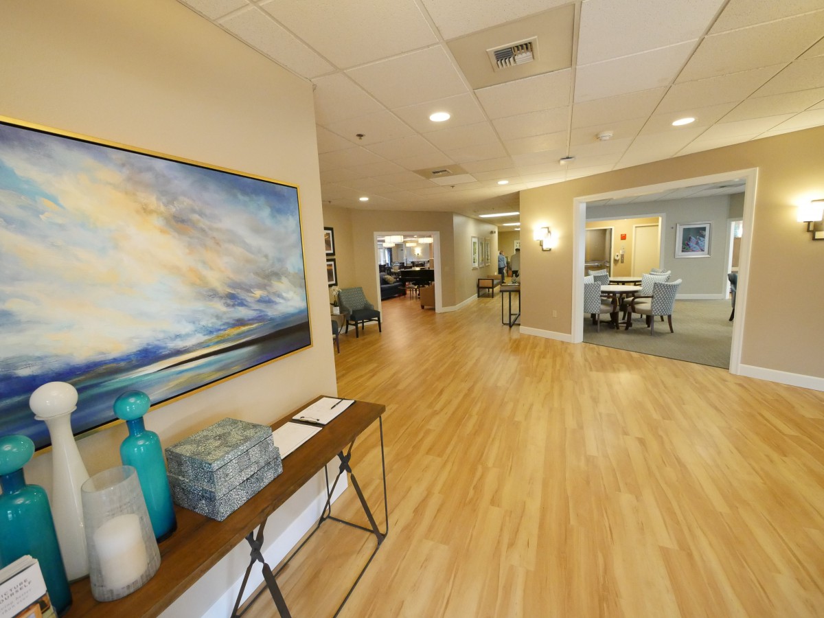A modern interior hallway with artwork and decorative furniture.