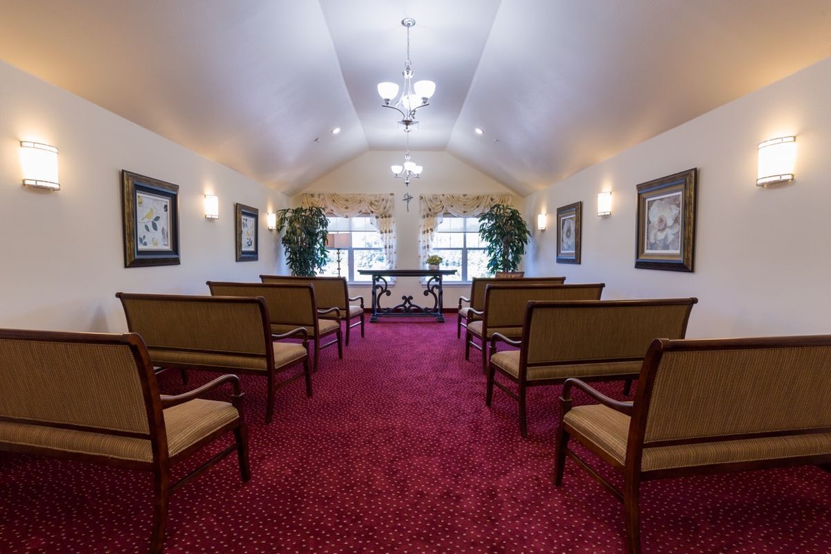 An interior view of a chapel with red carpeting and arranged seating.