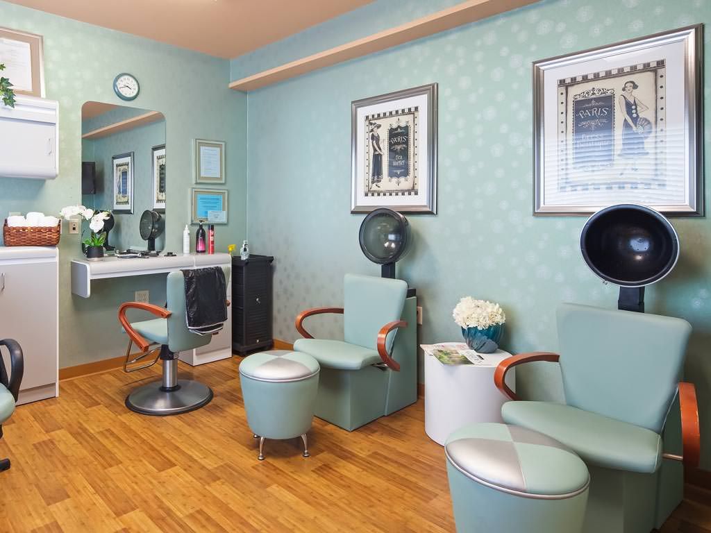 A modern hair salon interior featuring comfortable dryer chairs and stylish decor.
