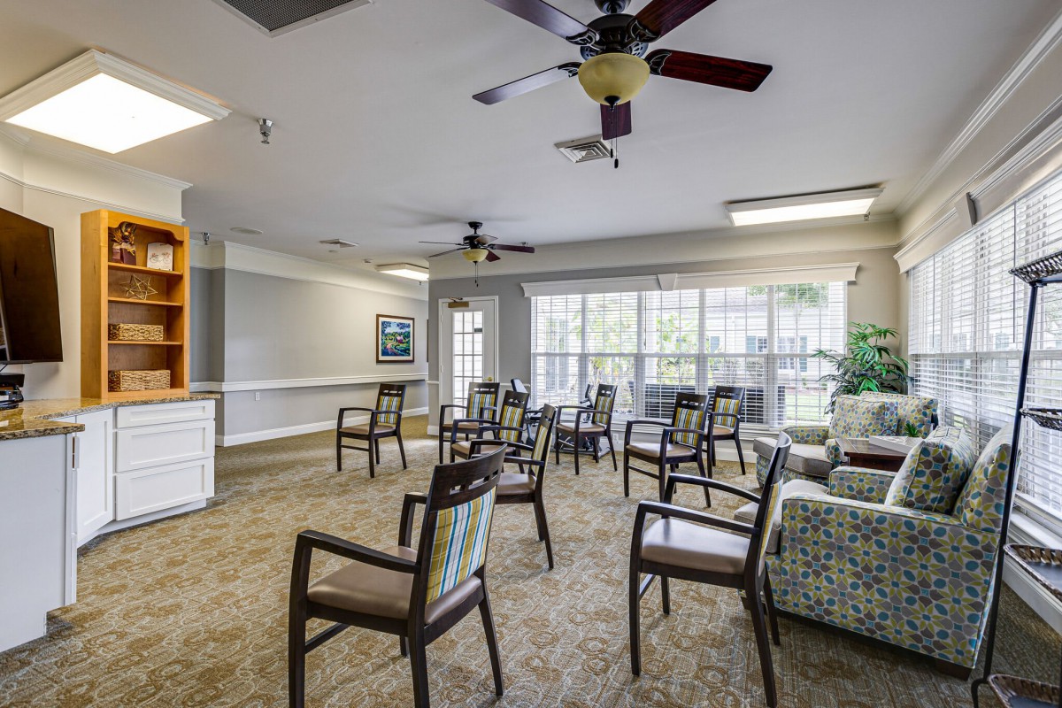 A well-lit meeting room with arranged chairs and large windows.