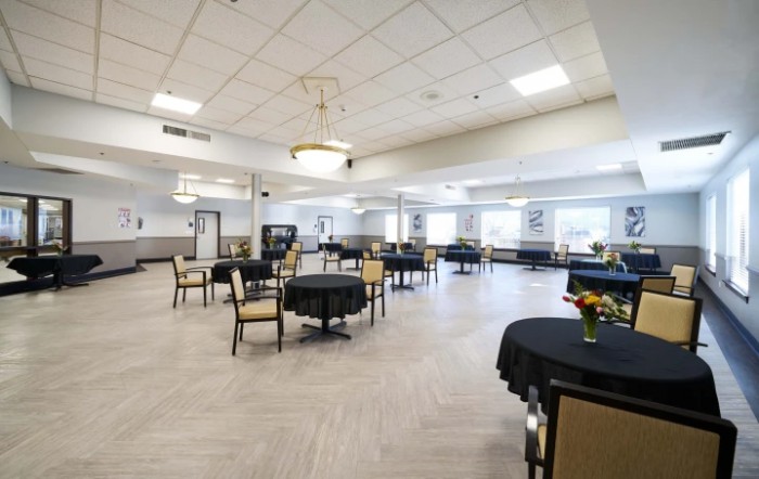 A spacious dining hall with neatly arranged tables and chairs.
