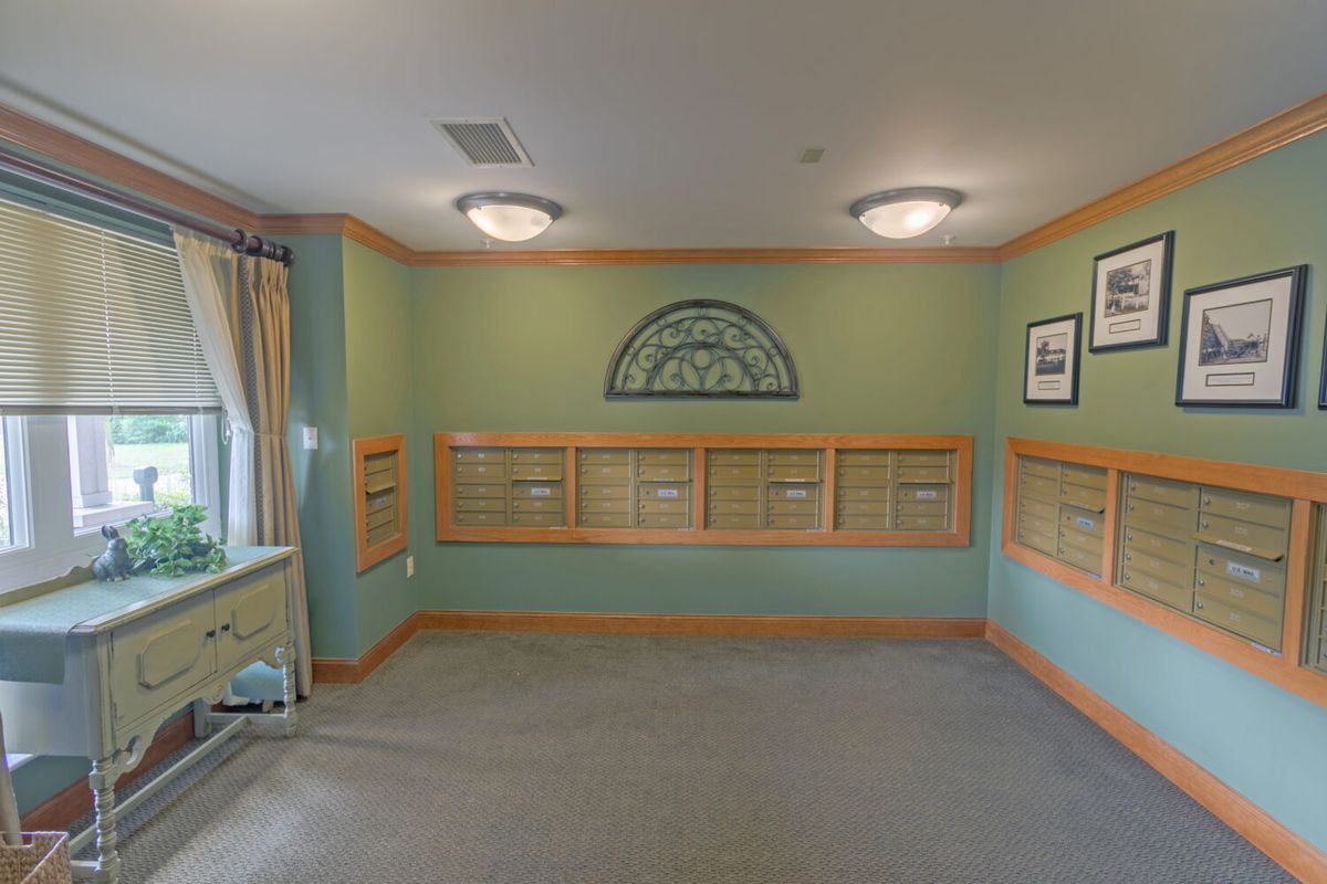 Empty mailroom with green walls and wooden trim.