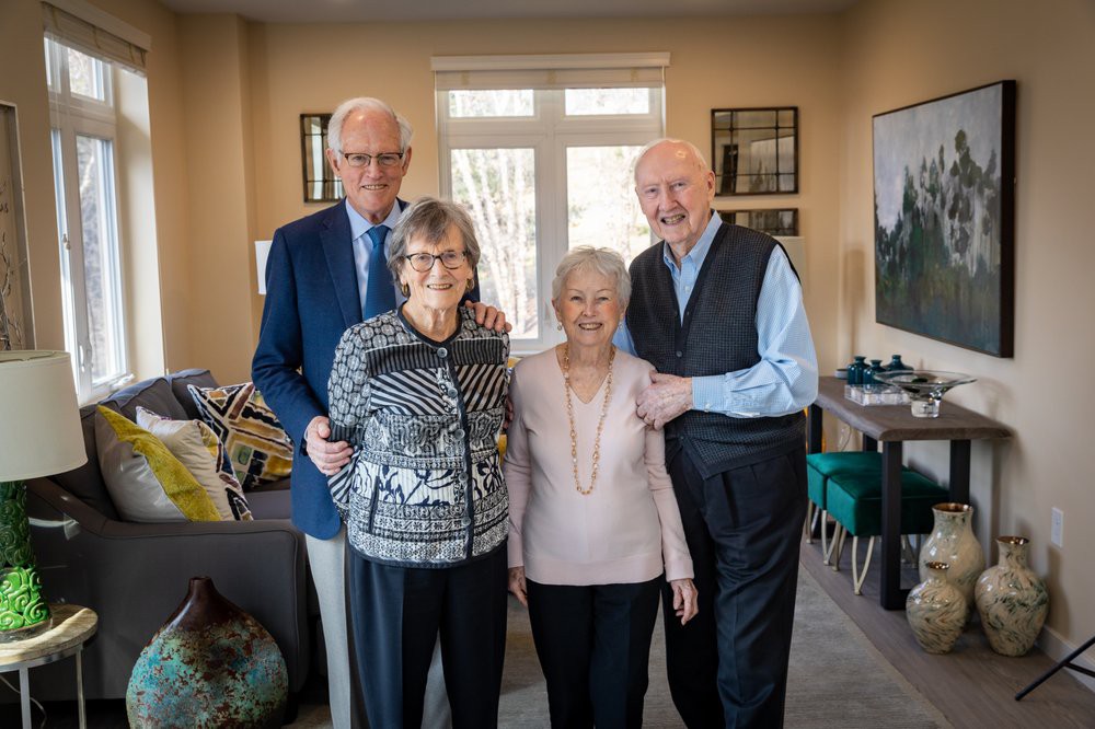 A group of four senior adults smiling indoors.