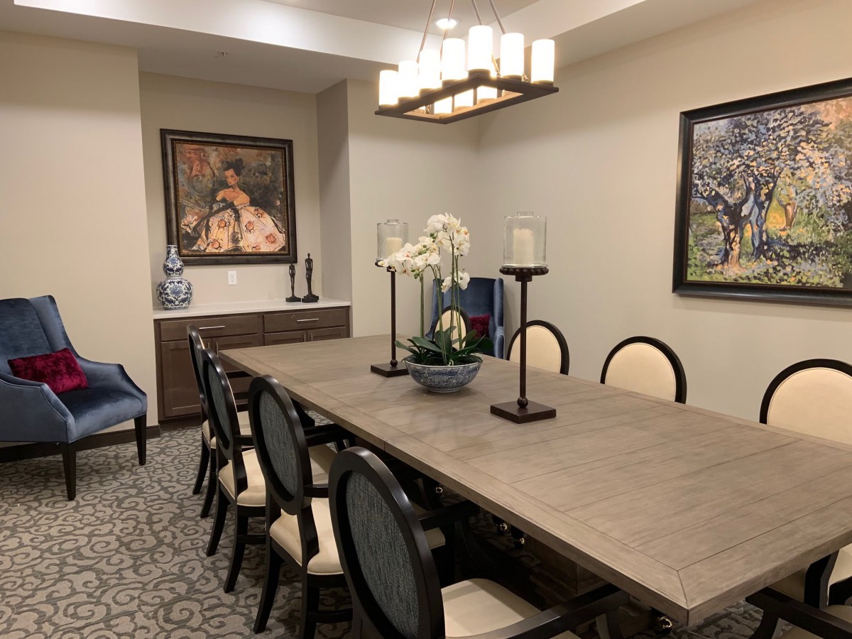 A well-decorated dining room with a large table, elegant chairs, and artistic decor.