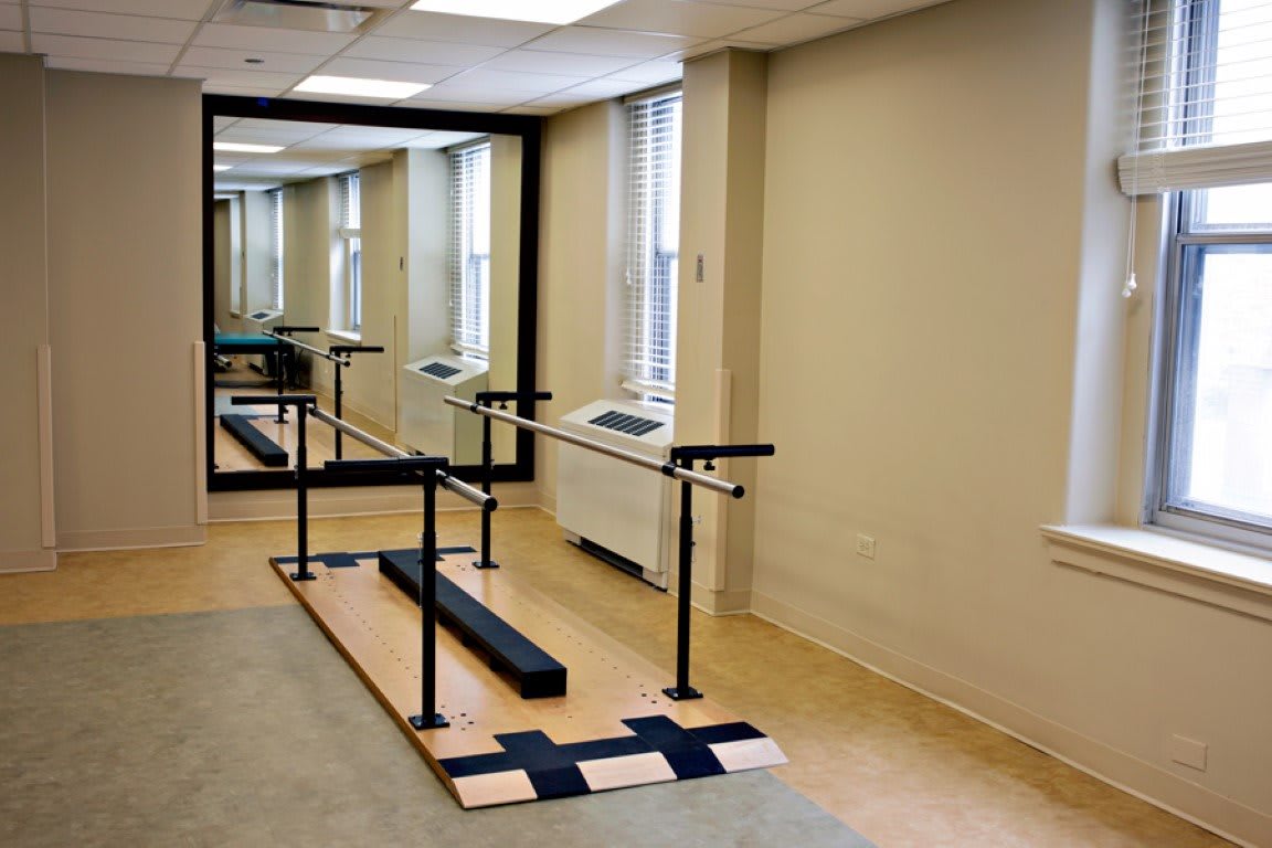 A rehabilitation room equipped with parallel bars for physical therapy exercises.