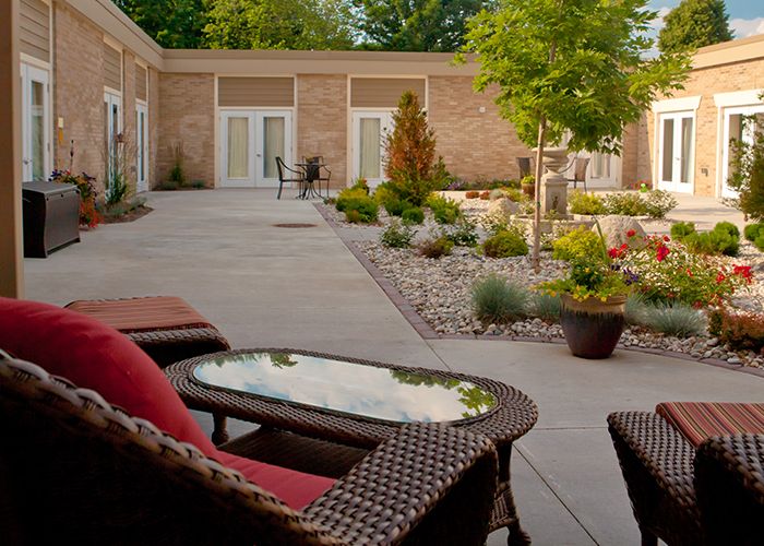 A tranquil courtyard featuring comfortable outdoor seating and a beautifully landscaped garden.