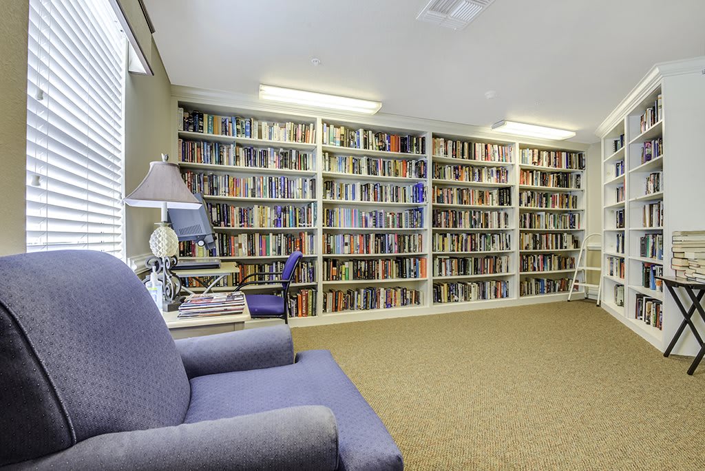 A cozy library with bookshelves filled with books and comfortable seating.