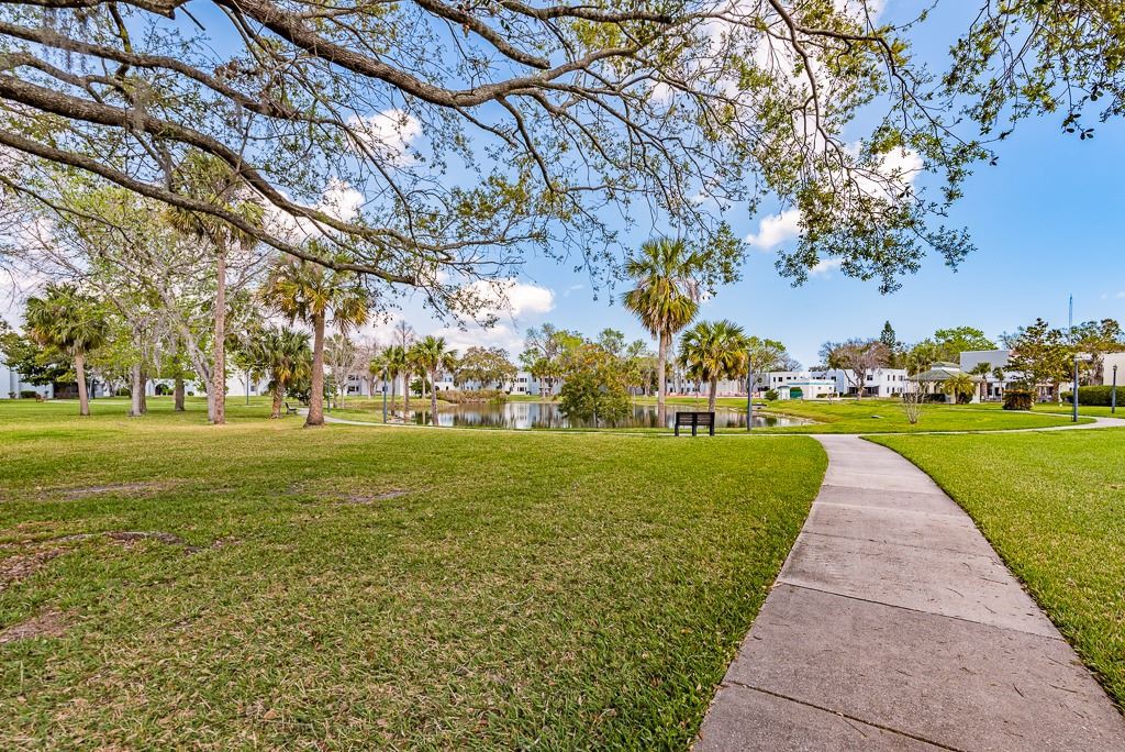 A scenic park with a winding pathway surrounded by trees and benches.
