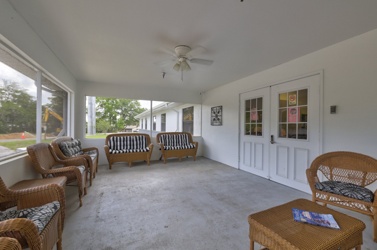 A spacious porch with comfortable seating and a ceiling fan.