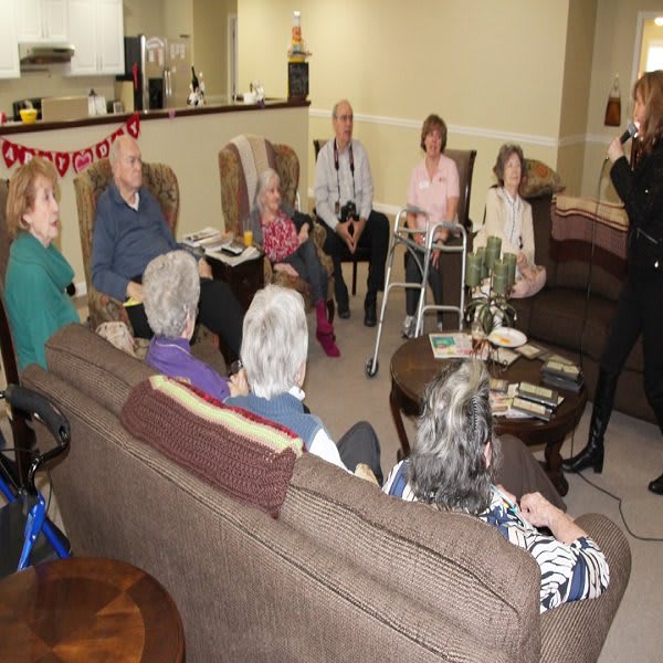 A group of seniors gathered in a living room for a social event.