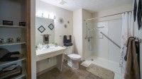 A modern bathroom interior featuring a sink, mirror, toilet, and shower.