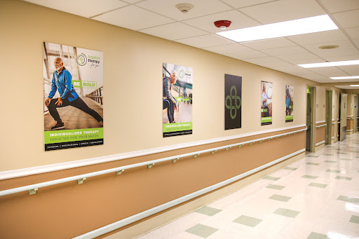A brightly lit hallway featuring motivational fitness posters, promoting health and rehabilitation.