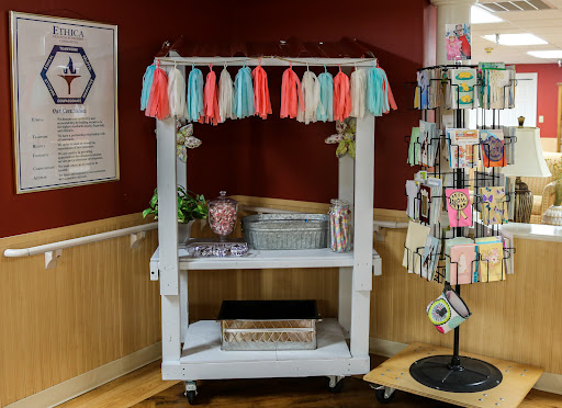 A charming display cart adorned with colorful tassels, perfect for showcasing handmade crafts.