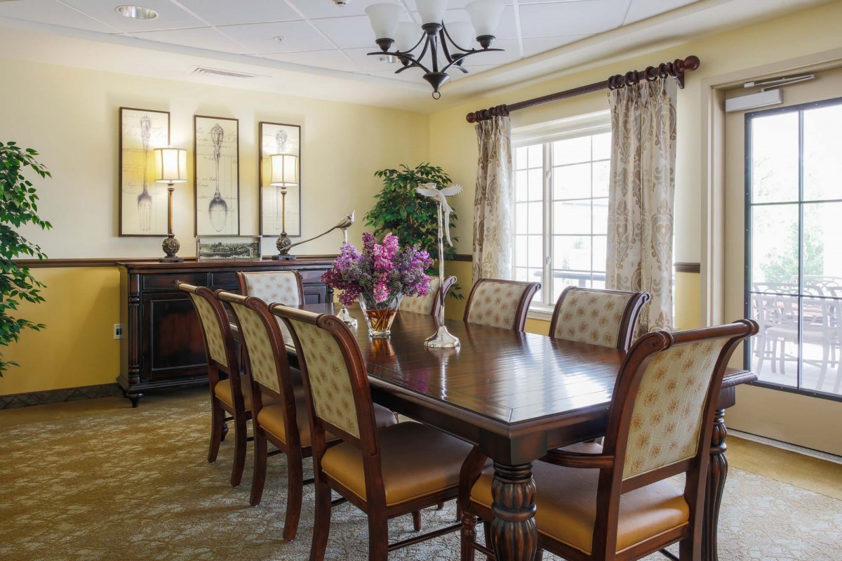 A well-furnished dining room with a wooden table, elegant chairs, and decorative elements.