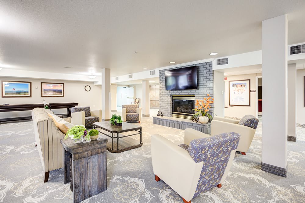 A modern living room featuring a cozy seating area with a fireplace and television.