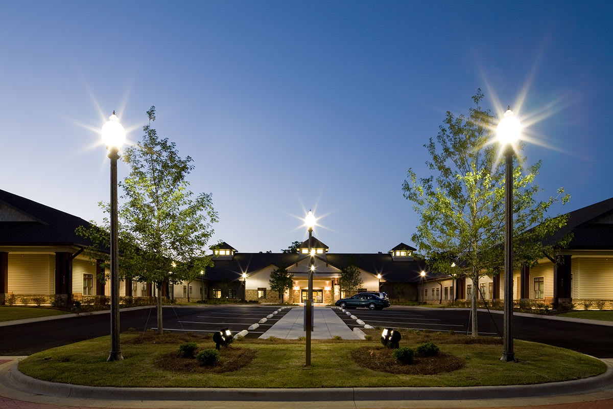 A well-lit building surrounded by trees at night.