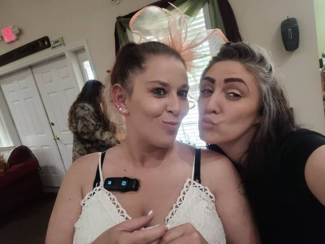 Two women posing for a playful selfie indoors.