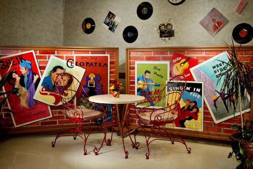 A cozy retro diner corner adorned with vibrant movie posters and classic music records, inviting you to enjoy a nostalgic ambiance.