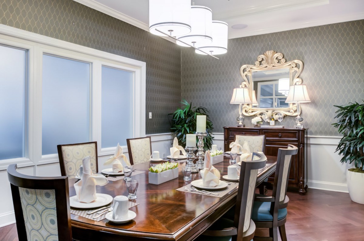 An elegant dining room with a beautifully set table and decorative mirror.