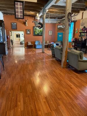 A cozy interior with hardwood flooring, comfortable seating, and diverse artwork displayed on the walls.