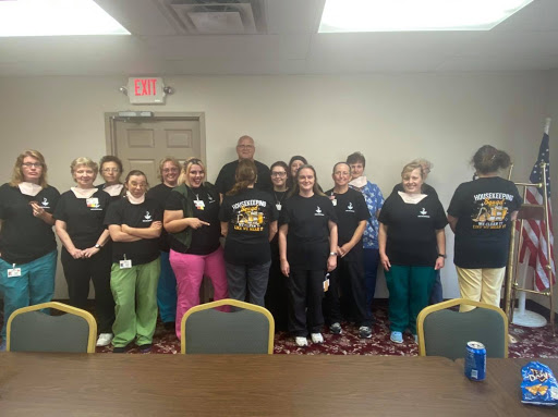 A group of individuals posing together in matching black shirts during an event.