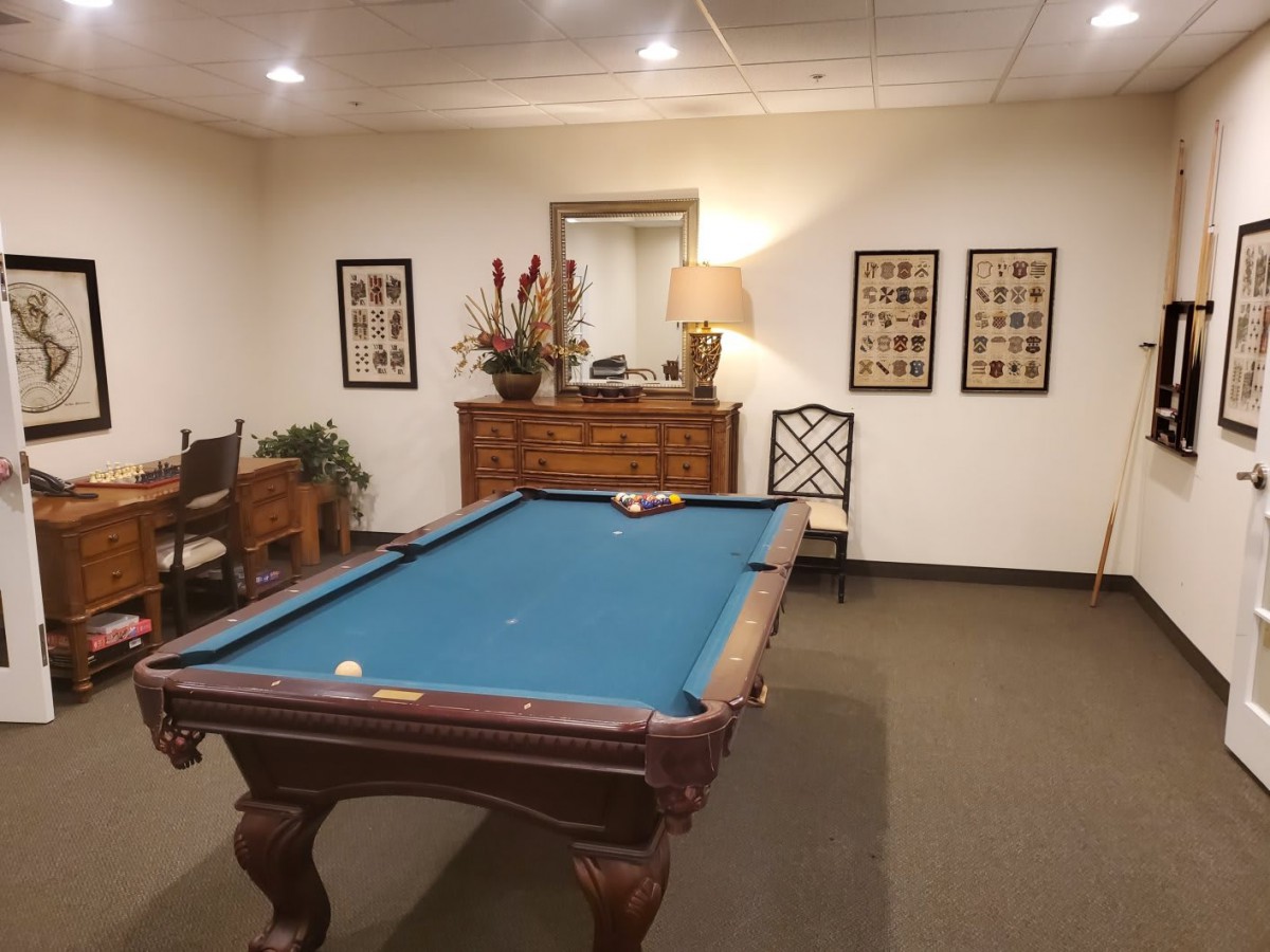 A classic game room featuring a billiard table surrounded by traditional decor and furniture.