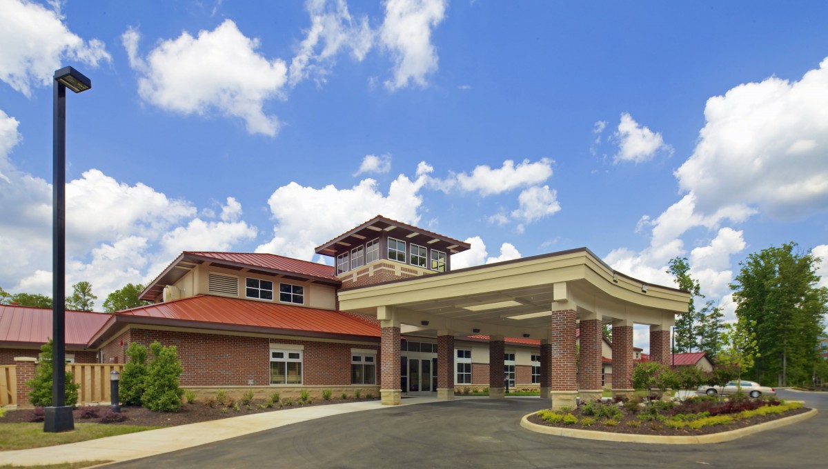 A modern healthcare facility with a welcoming entrance under a bright blue sky.