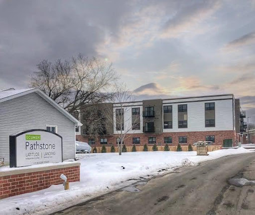 A view of a residential building surrounded by snow on a cloudy winter day.