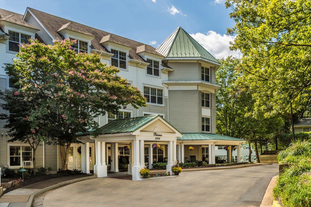 A charming hotel exterior with a welcoming entrance surrounded by trees.
