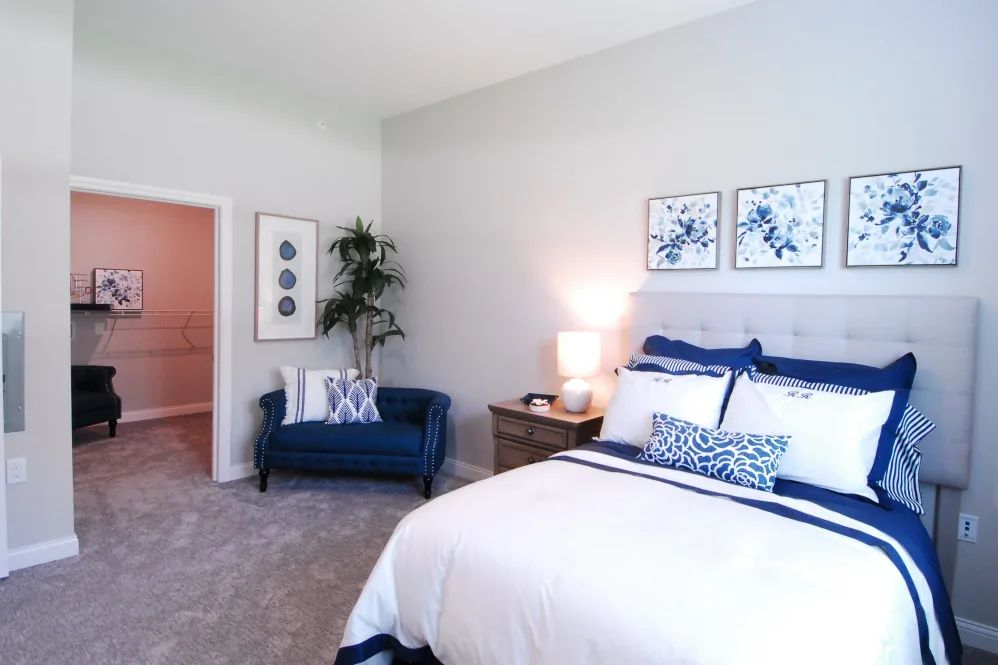 A modern bedroom with a cozy bed, stylish decor, and a comfy sofa.