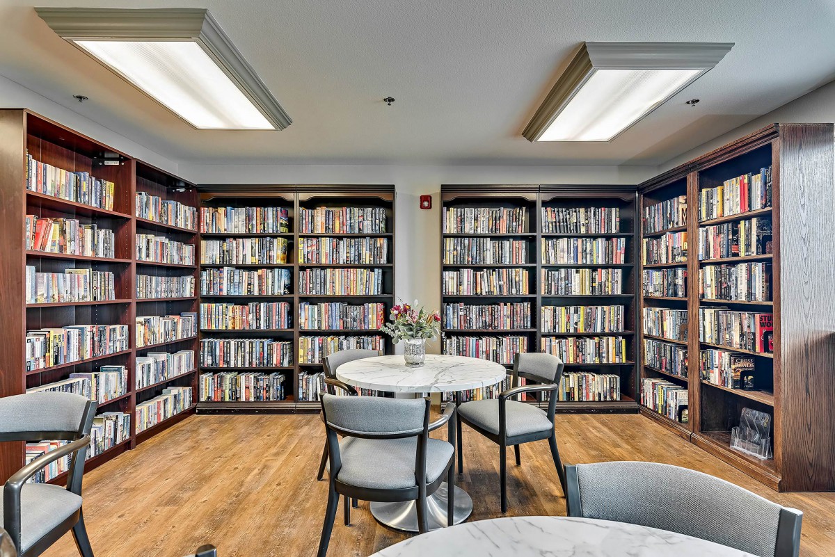 Cozy library with a reading area and bookshelves filled with literature.