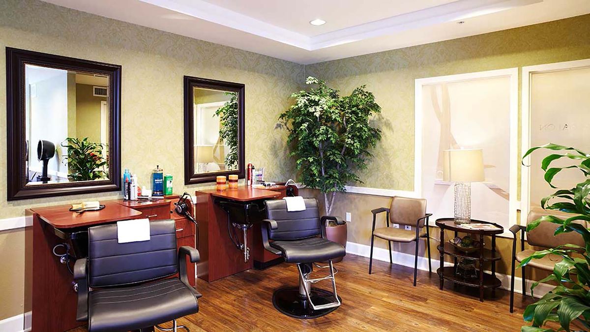 A cozy hair salon interior with styling chairs and a waiting area.
