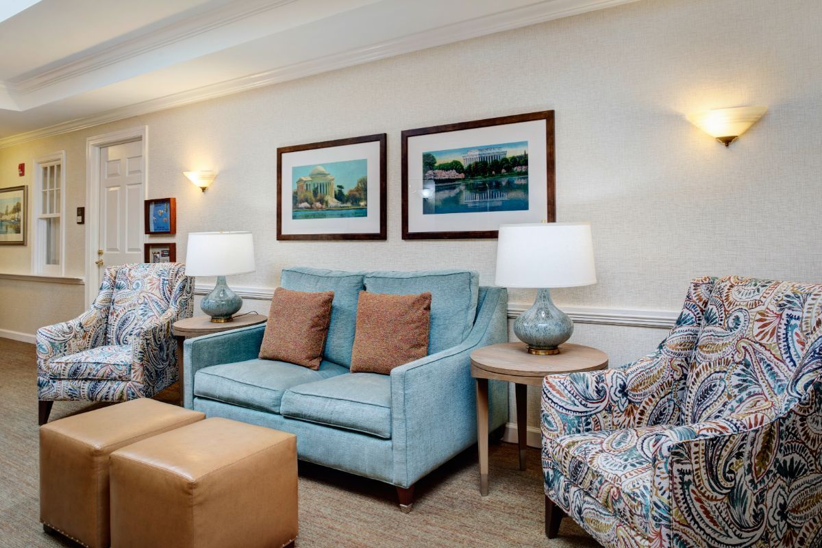 A cozy living room with a blue sofa, patterned armchair, and complementary decor.