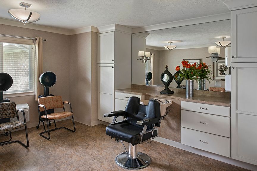 A well-designed beauty salon interior with a styling chair, large mirror, and decorative items.