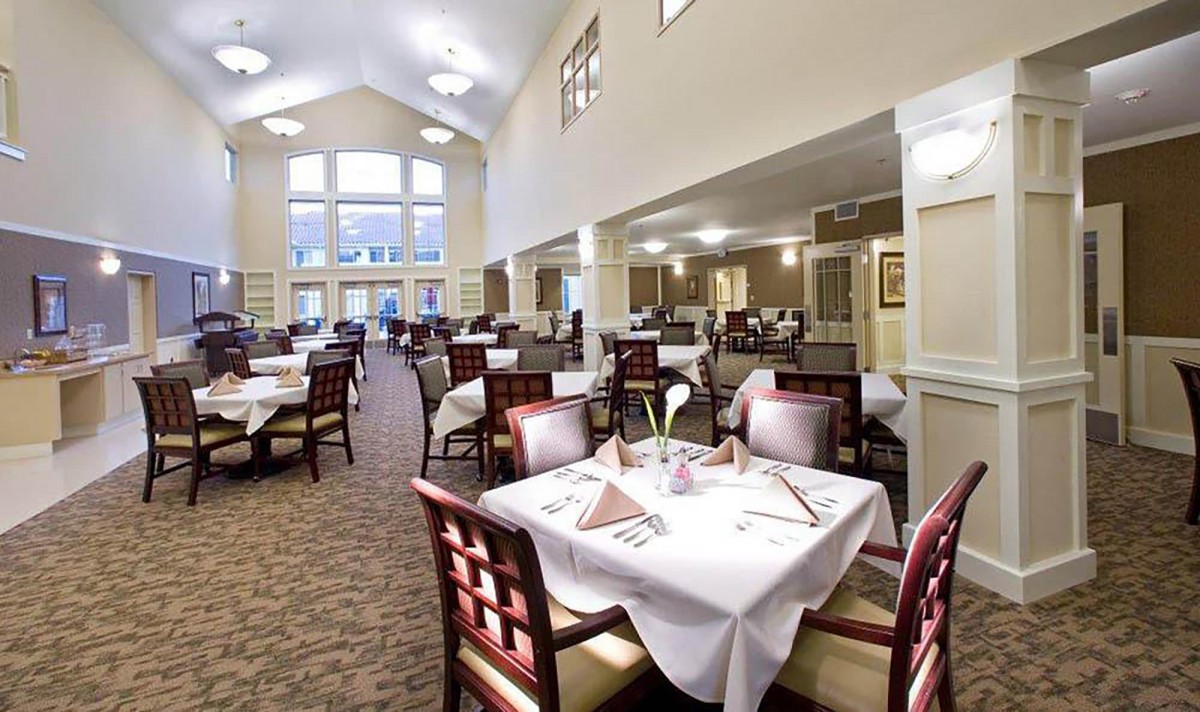 A spacious dining area with elegantly set tables and natural lighting.