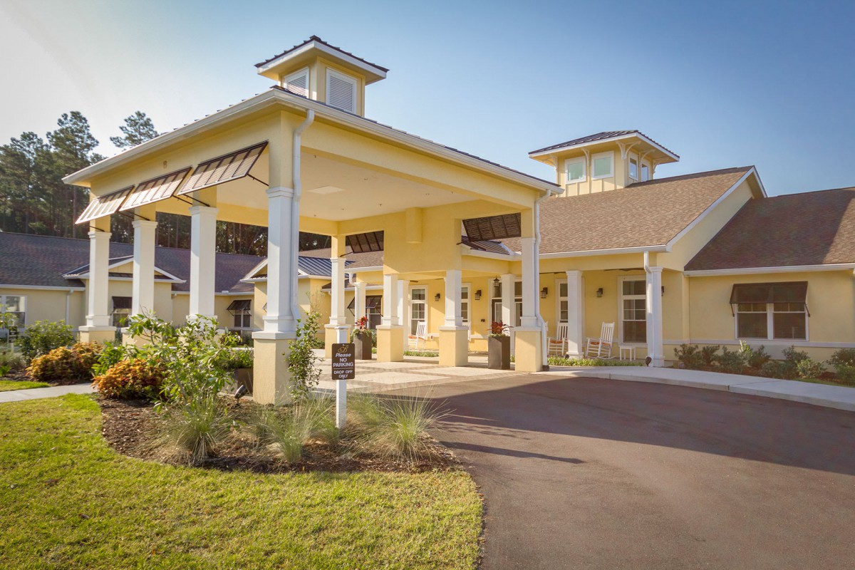 A welcoming residential building with a covered entryway and surrounding landscape.
