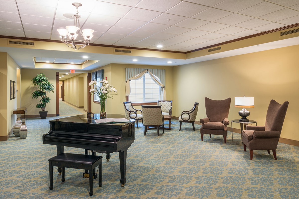 A cozy hotel lounge with a grand piano and comfortable seating.