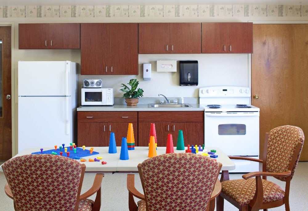 A kitchen area with cabinets, appliances, and a table set with colorful cones.