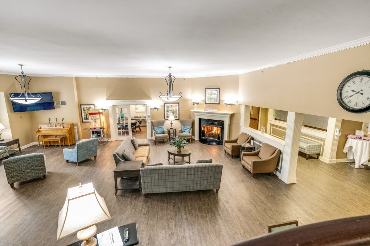 A cozy living room with a central seating area and a fireplace.